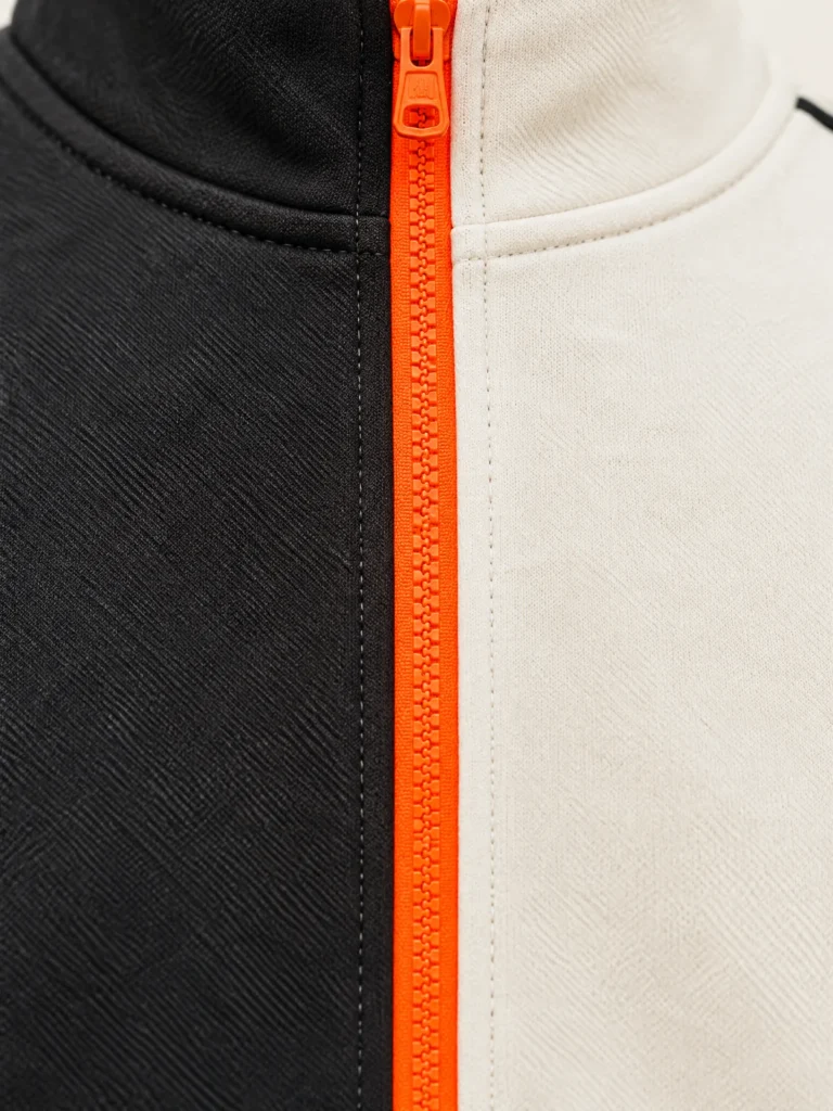Close-up of Signal-orange centre zip on Kerb Contrast Jacket