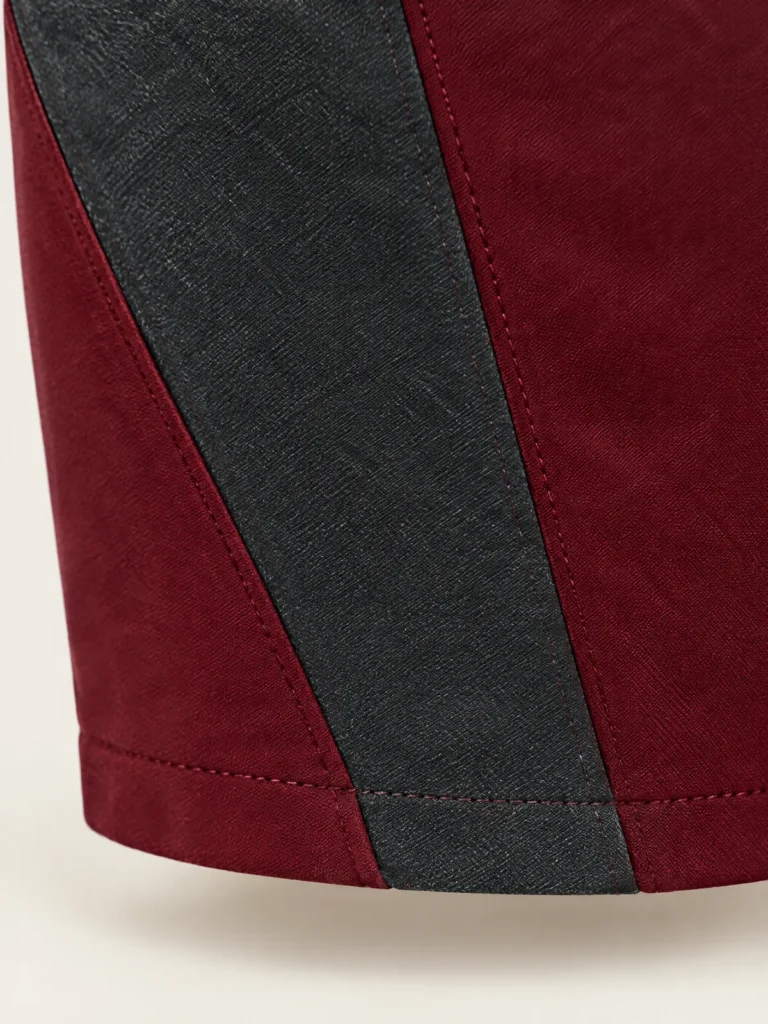 Close-up of asymmetric Asphalt panel tapering toward hem on Oxblood skirt