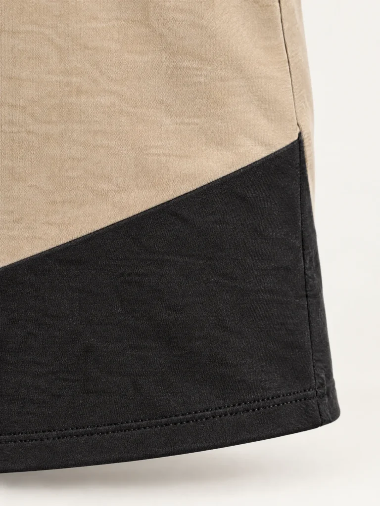 Close-up of diagonal Asphalt panel rising across Sand jersey boat neck top