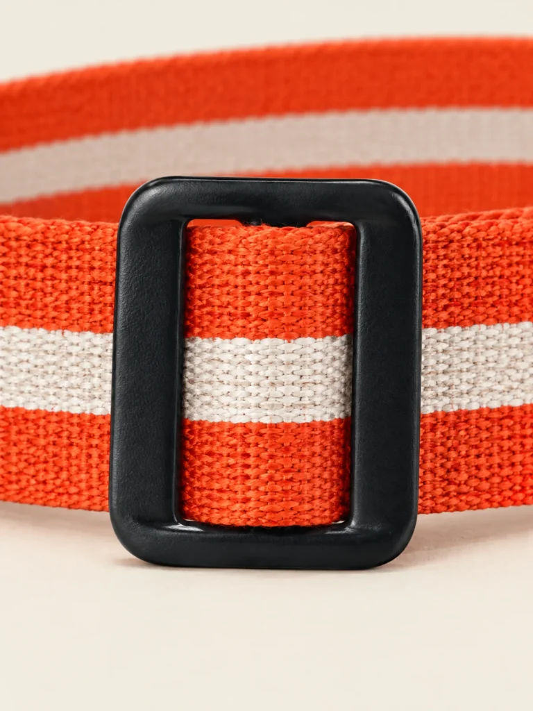 Close-up of matte black slider buckle and striped webbing on belt