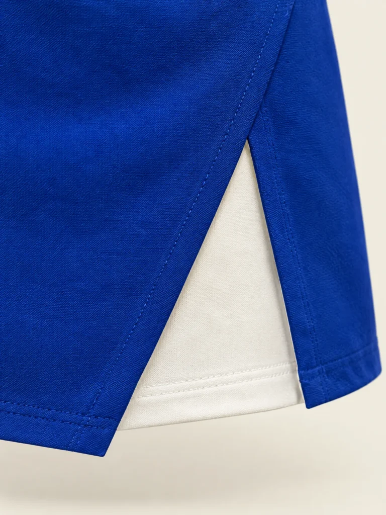 Close-up of diagonal front split hem revealing Chalk underlayer panel